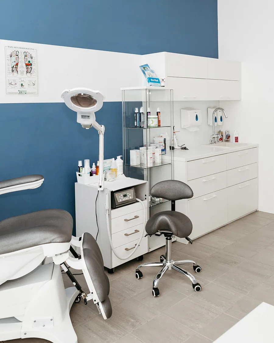 Gabinet podologiczny FootMedica z fotelem przy granatowej ścianie