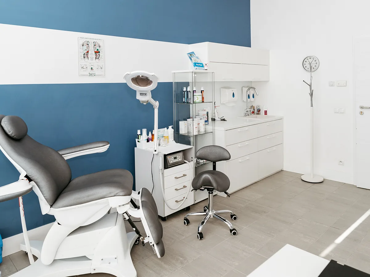 Gabinet podologiczny FootMedica z fotelem przy granatowej ścianie