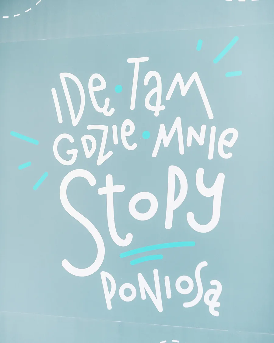 Ściana kliniki z hasłem „Idę tam, gdzie mnie stopy poniosą”