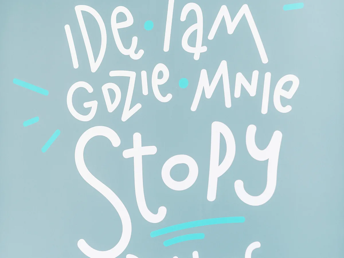 Ściana kliniki z hasłem „Idę tam, gdzie mnie stopy poniosą”
