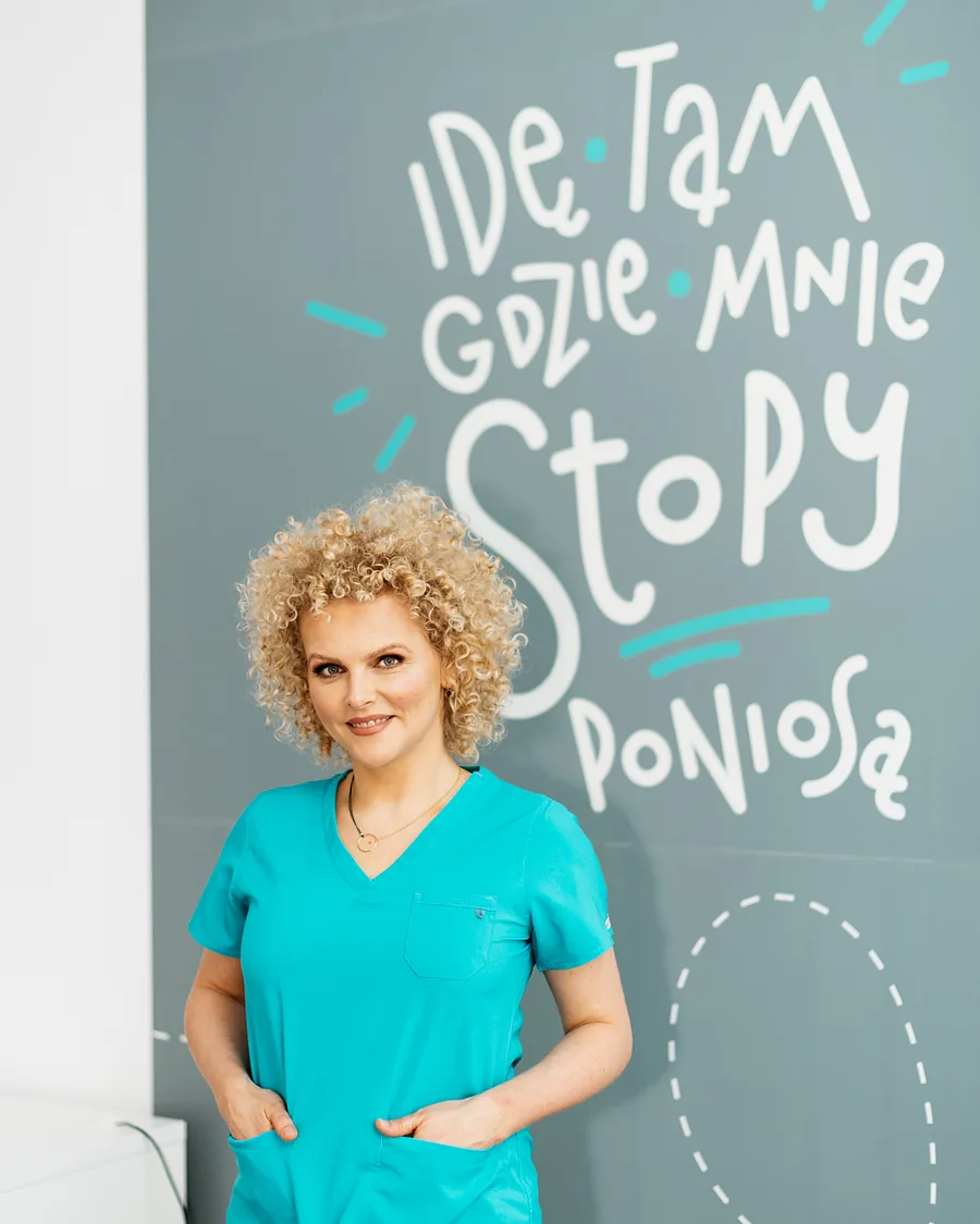 Joanna Stodolna-Tukendorf przy ścianie z hasłem kliniki