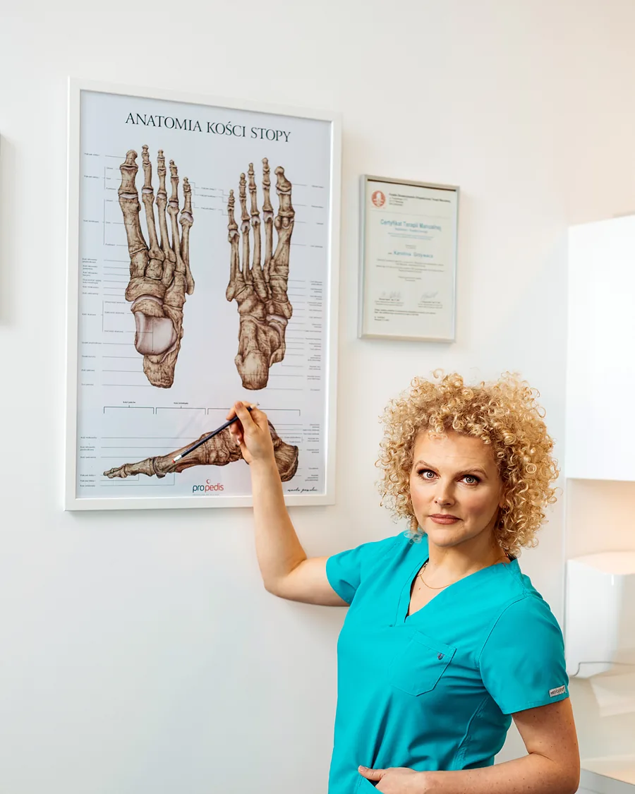 Joanna Stodolna-Tukendorf wskazuje planszę z anatomią kości stopy