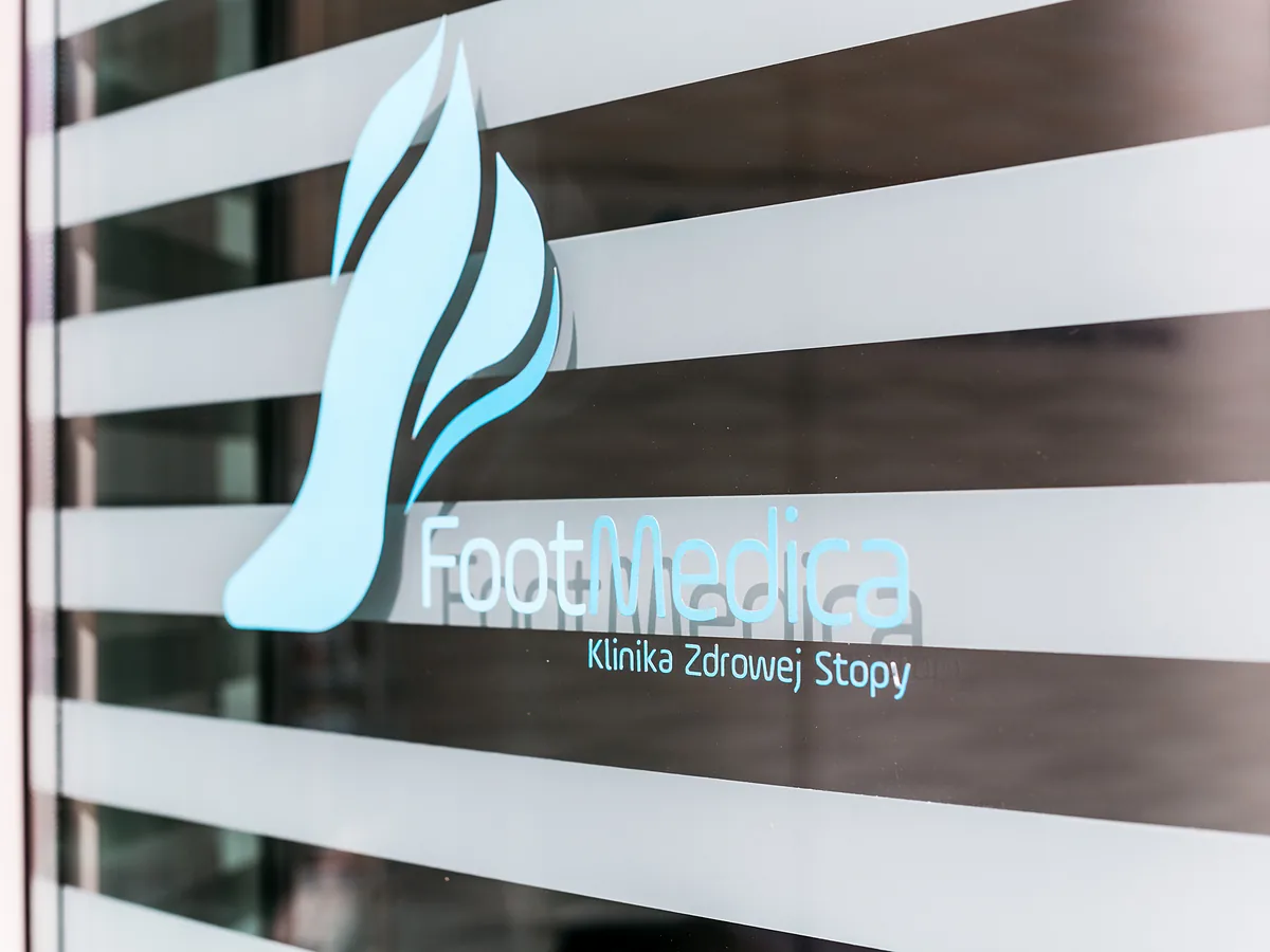 Logo FootMedica na szklanych drzwiach kliniki
