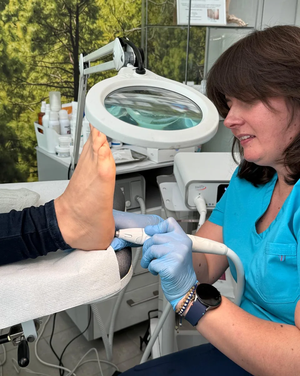 Podolog FootMedica przy pracy pod lampą z lupą